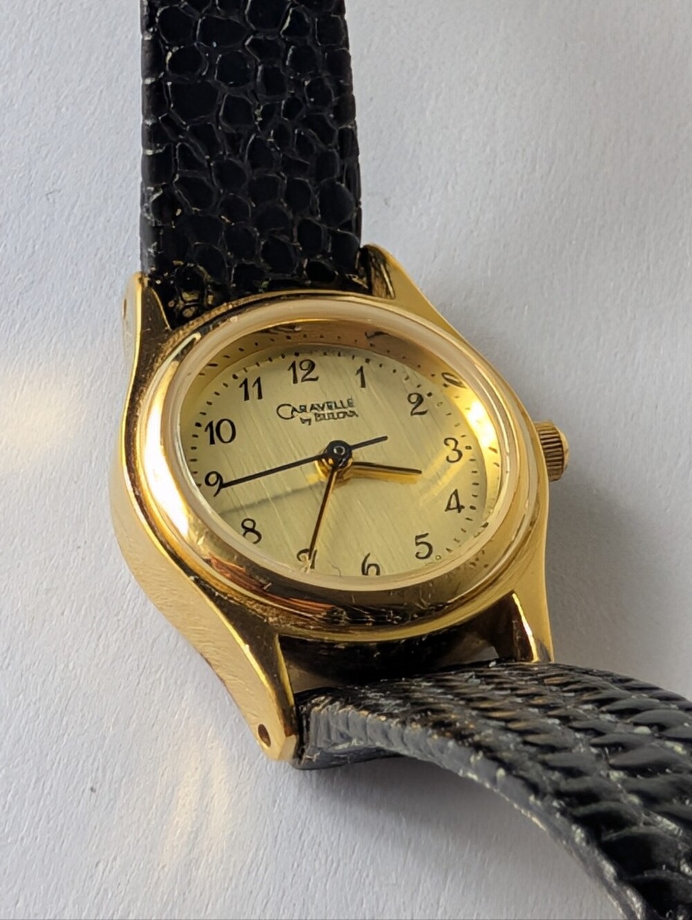 Caravelle by Bulova Gold Tone Black Embossed Leather Strap Watch